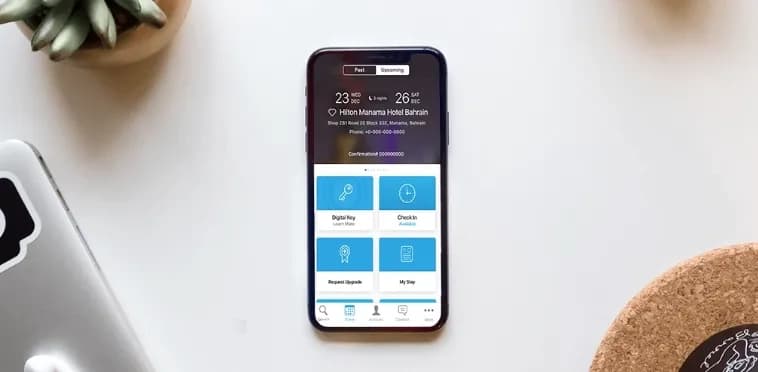 Hilton Honors app on a phone showing an upcoming Bahrain stay with Digital Key, Check-in and Request Upgrade tiles