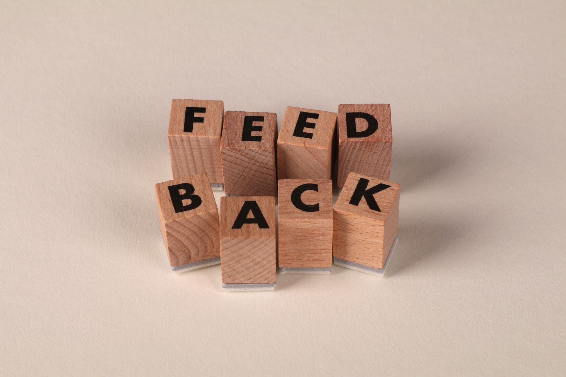 Wooden blocks spelling the word feedback on a neutral background