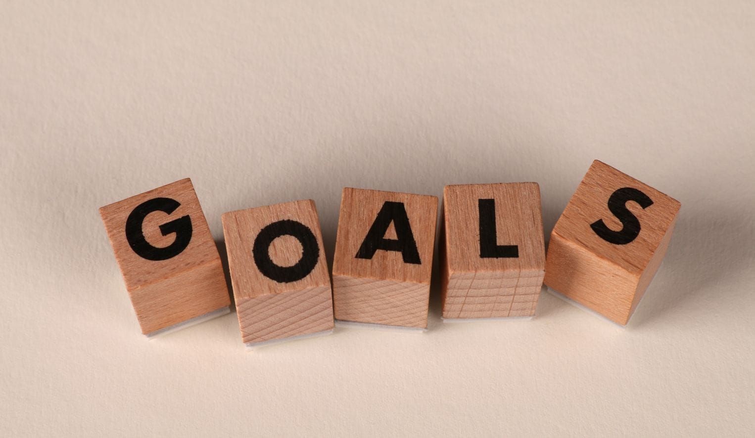 Wooden blocks spelling GOALS, illustrating customer retention goals