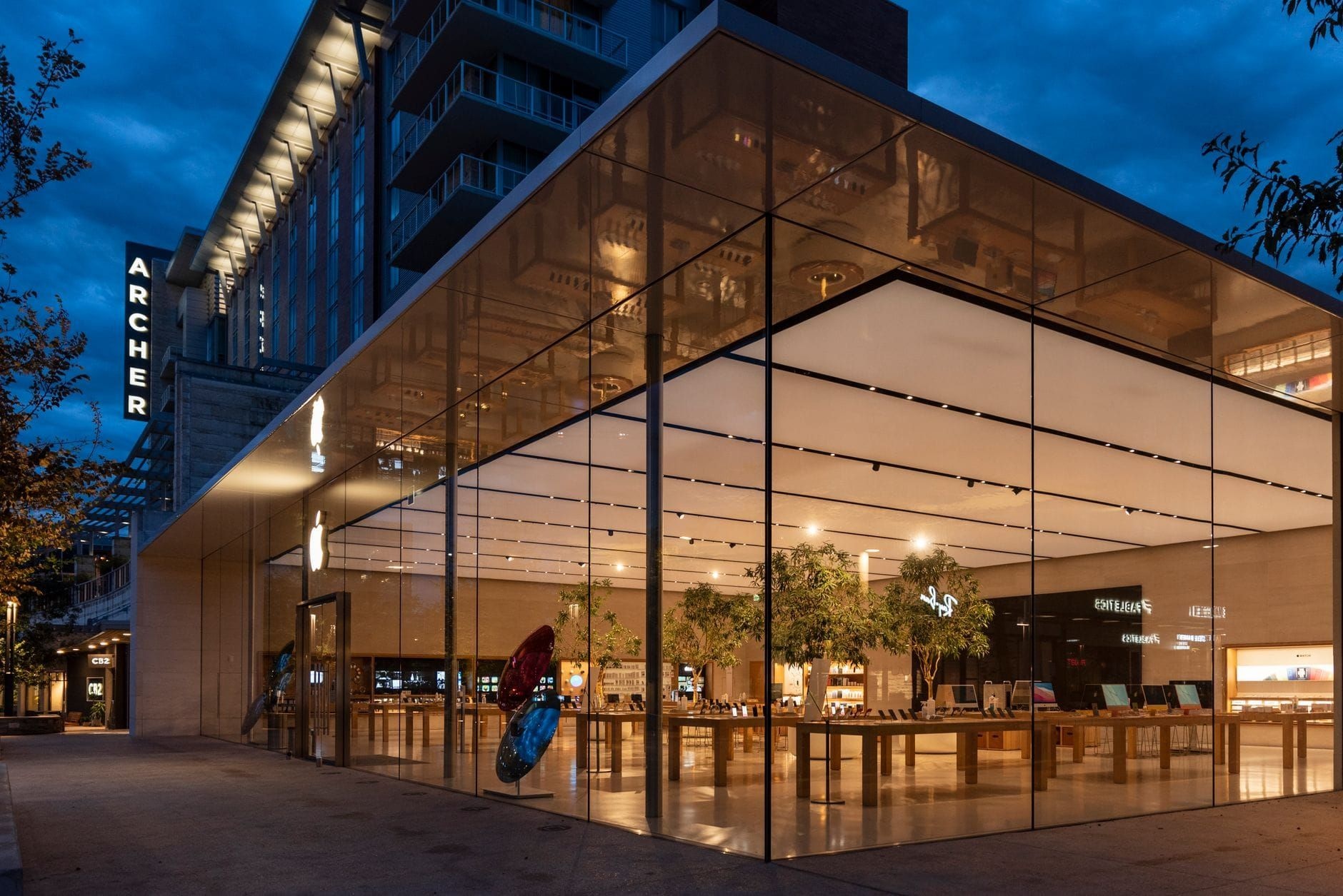 Apple Store with a lit glass facade at dusk