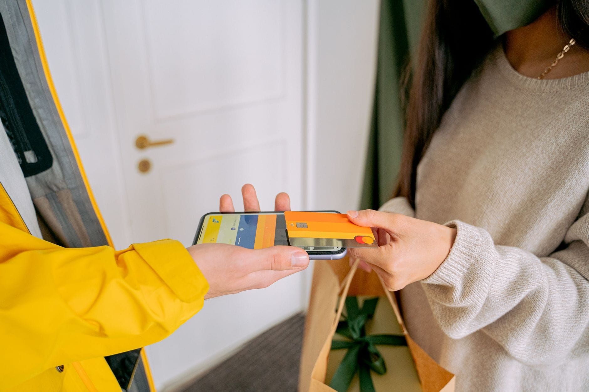 Customer paying by phone while receiving a delivery at the door