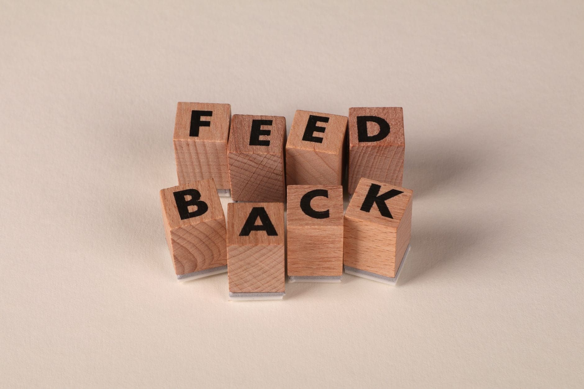 Wooden blocks spelling the word feedback on a neutral background