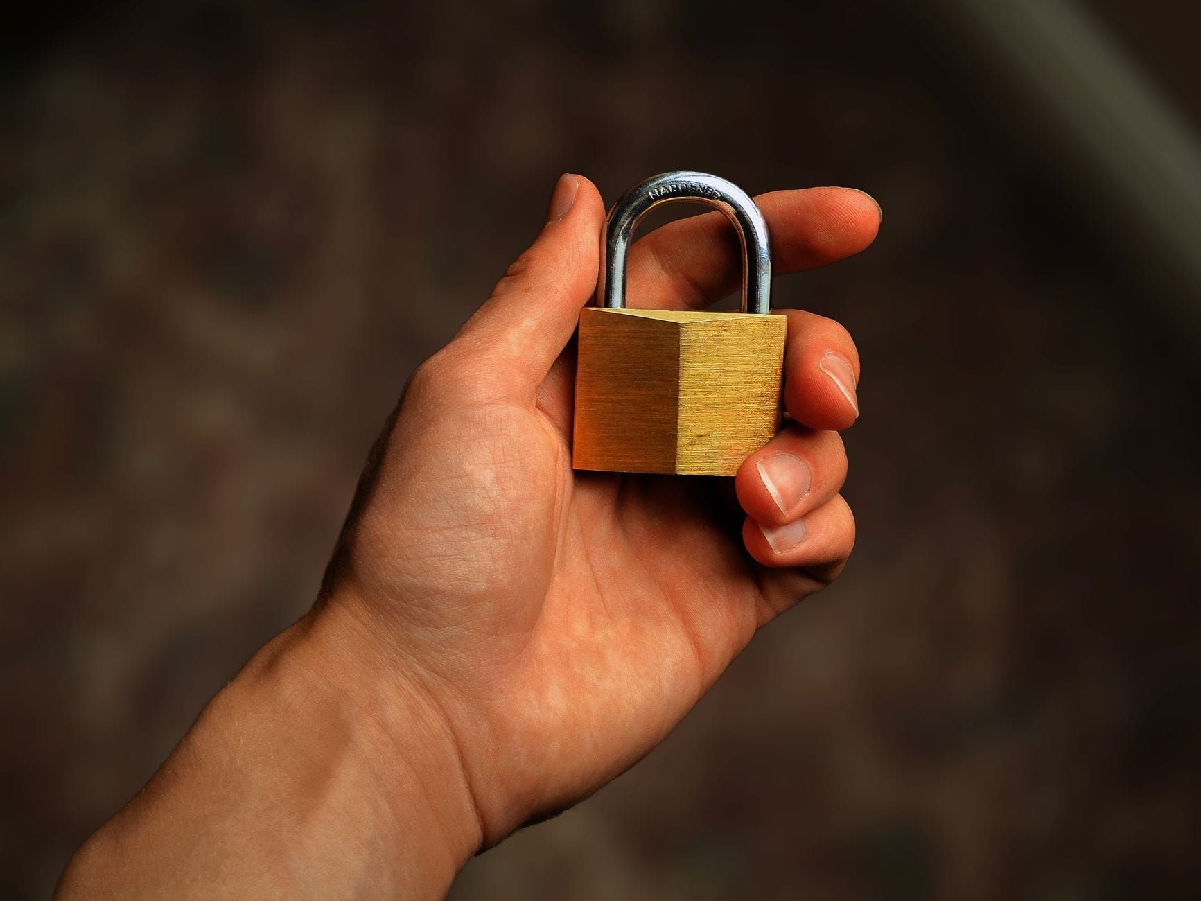 Hand holding a brass padlock
