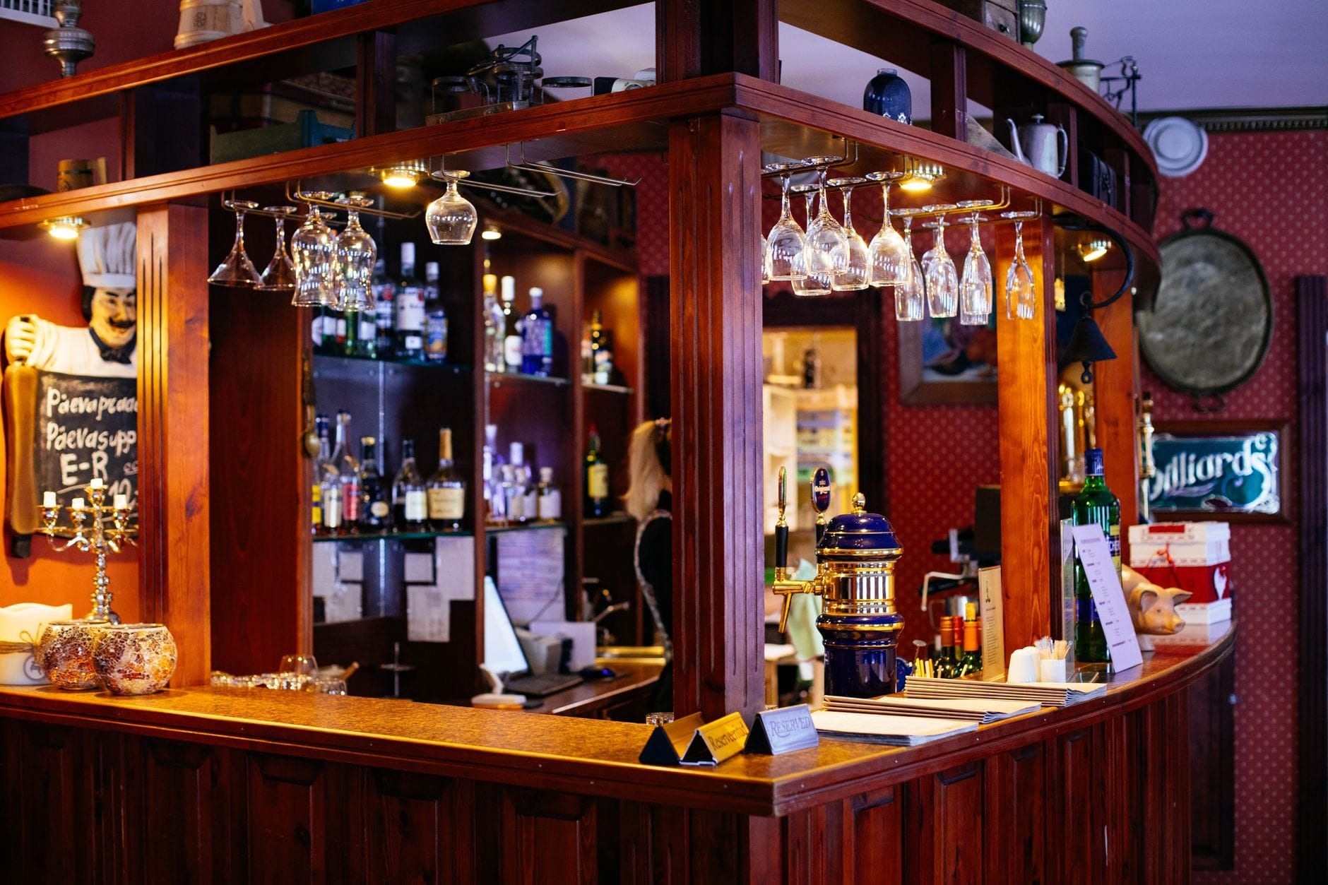 Warm wooden pub bar lined with glassware under amber light