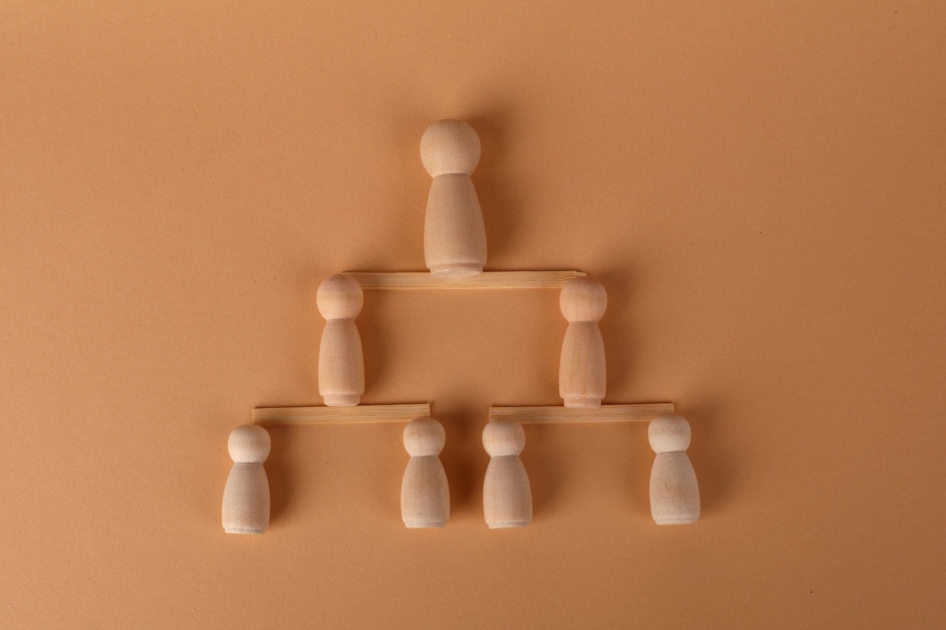 Wooden peg figures arranged into a multi-tier pyramid